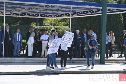 Arrests of two people who held up protest placards at the Athens parade