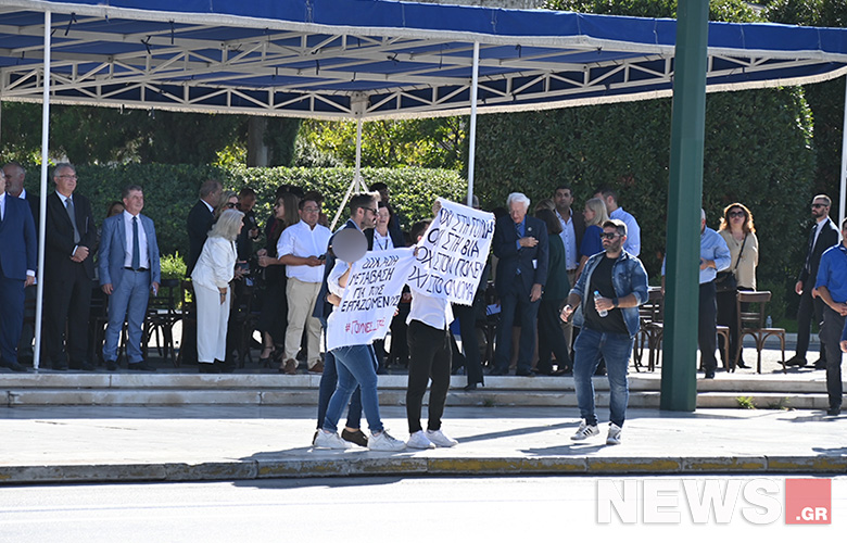 Arrests of two people who held up protest placards at the Athens parade